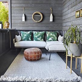 Backdoor covered porch featuring Thermally Modified Big Sky wood cladding couch tassel rug plant leather poof