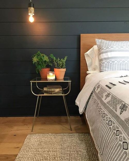 Black smooth shiplap accent wall in bedroom by Joanna Gaines