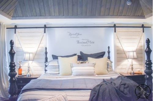 Rustic white shiplap barn doors and charred ash gray on the ceiling of bedroom