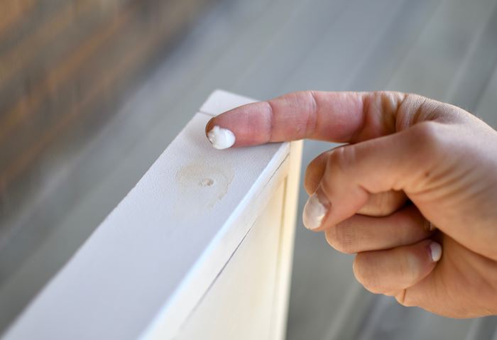 Add wood filler to the nail holes of your shiplap sign