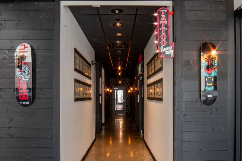 Hallway with two walls on each side covered in Native Woods Nightfall shiplap with skateboards on display