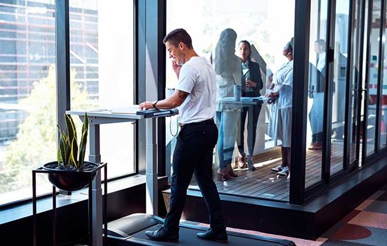 Business professional working at stationary desk treadmill