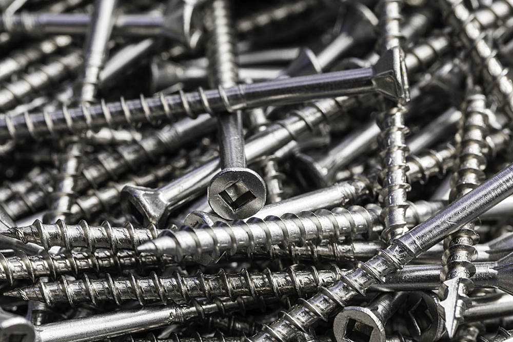 A closeup of a pile of stainless steel fasteners