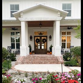 Modern white farmhouse front entry with pro column structural posts floral landscape