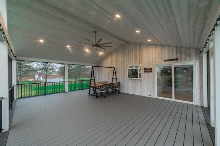 Backyard covered screened in porch vaulted ceiling and accent wall featuring Thermally Modified Glacier wood cladding