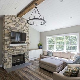 Modern living room with fireplace featuring primed white timeless nickel gap shiplap ceiling