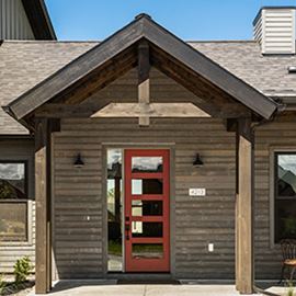Montana home front entry porch wrapped in UFP-Edge Thermally Modified Big Sky Wood Cladding with red door