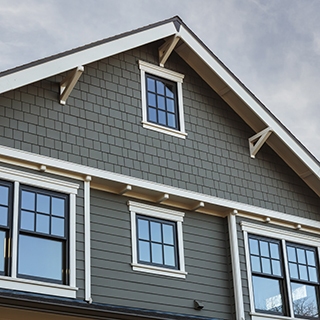 Gray house gable with windows UFP-Edge primed SPF trim and fascia