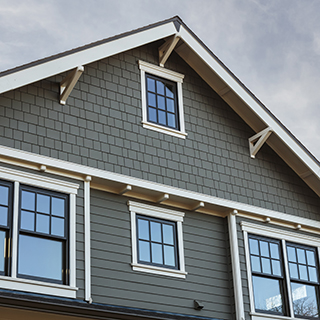 Gray house gable with windows UFP-Edge primed SPF trim and fascia 