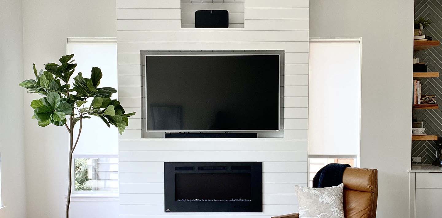 White living room with Timeless Farmhouse White shiplap built-ins TV and fireplace